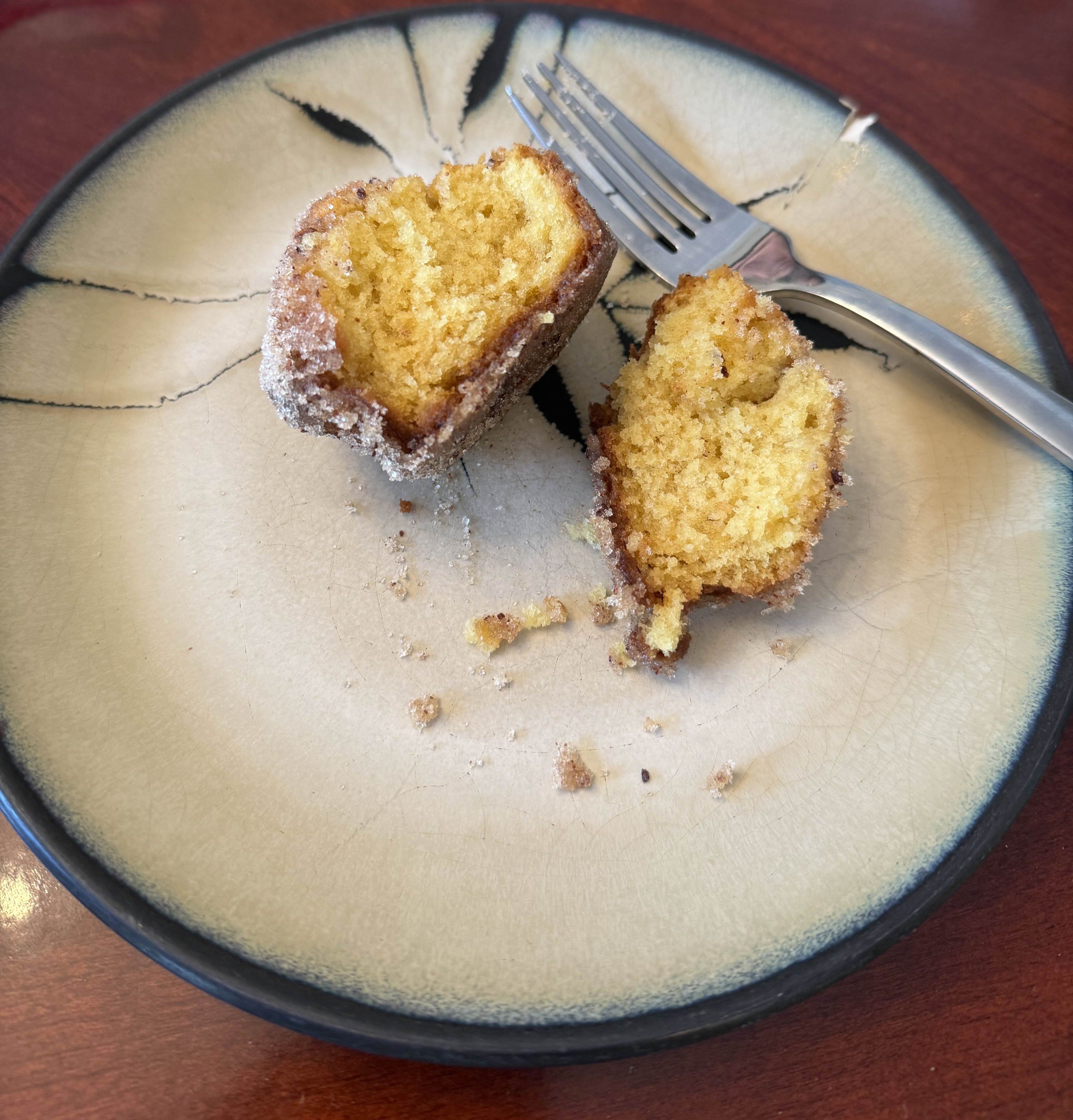 A dirt bomb split open on a plate, showing its yellow crumb.