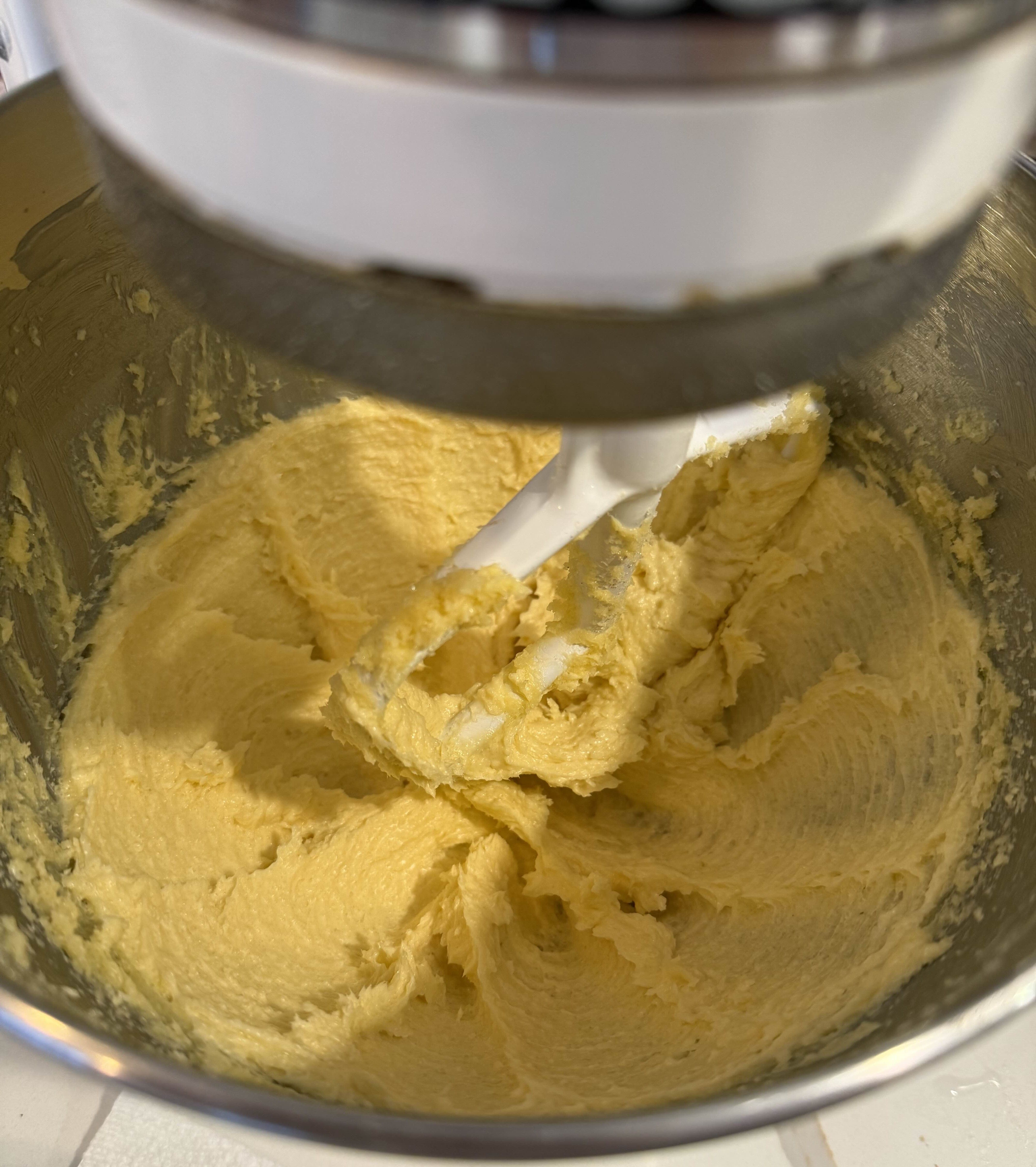 Butter being beat using a paddle attachment in a stand mixer