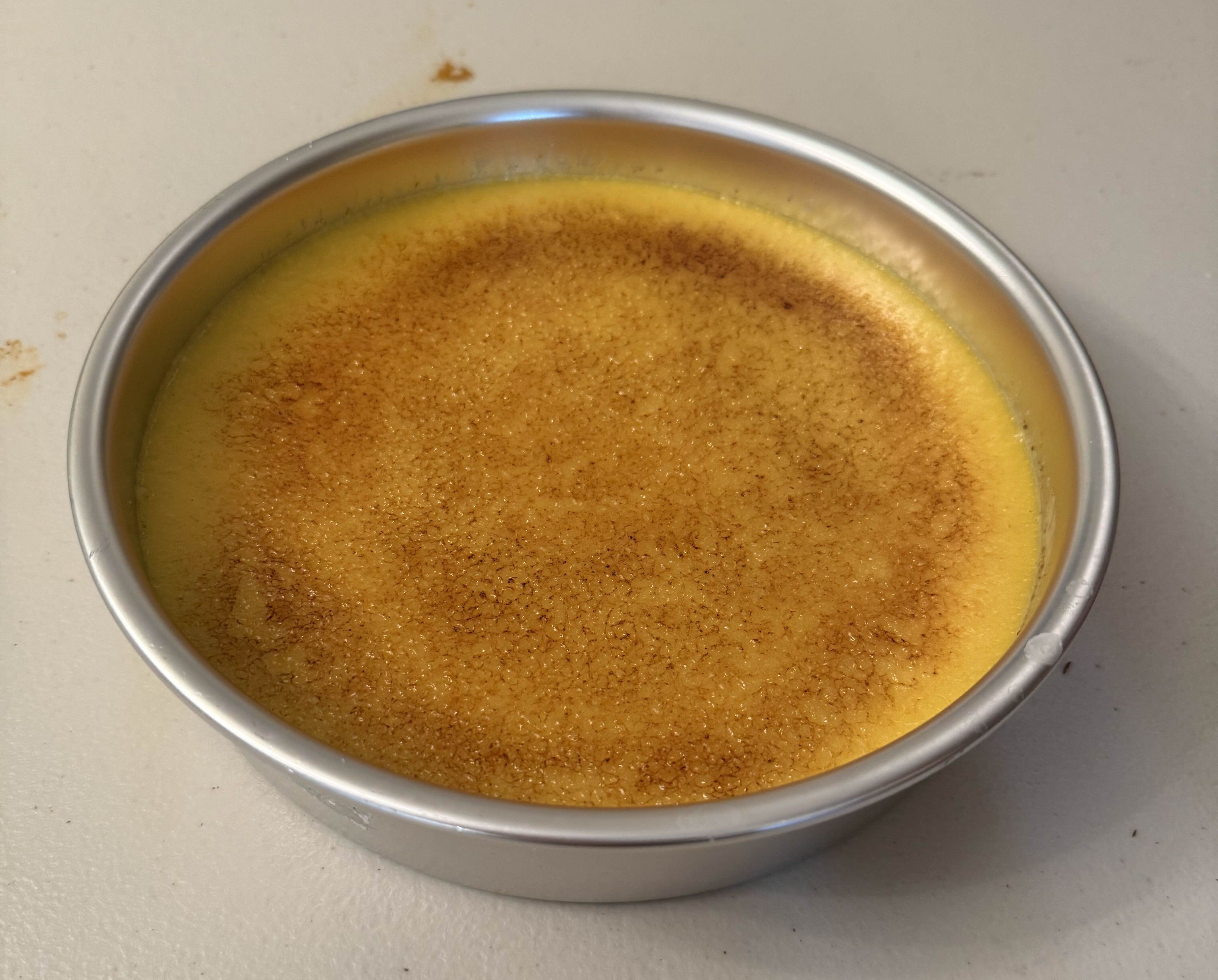 Creme brulee in a round aluminum cake pan