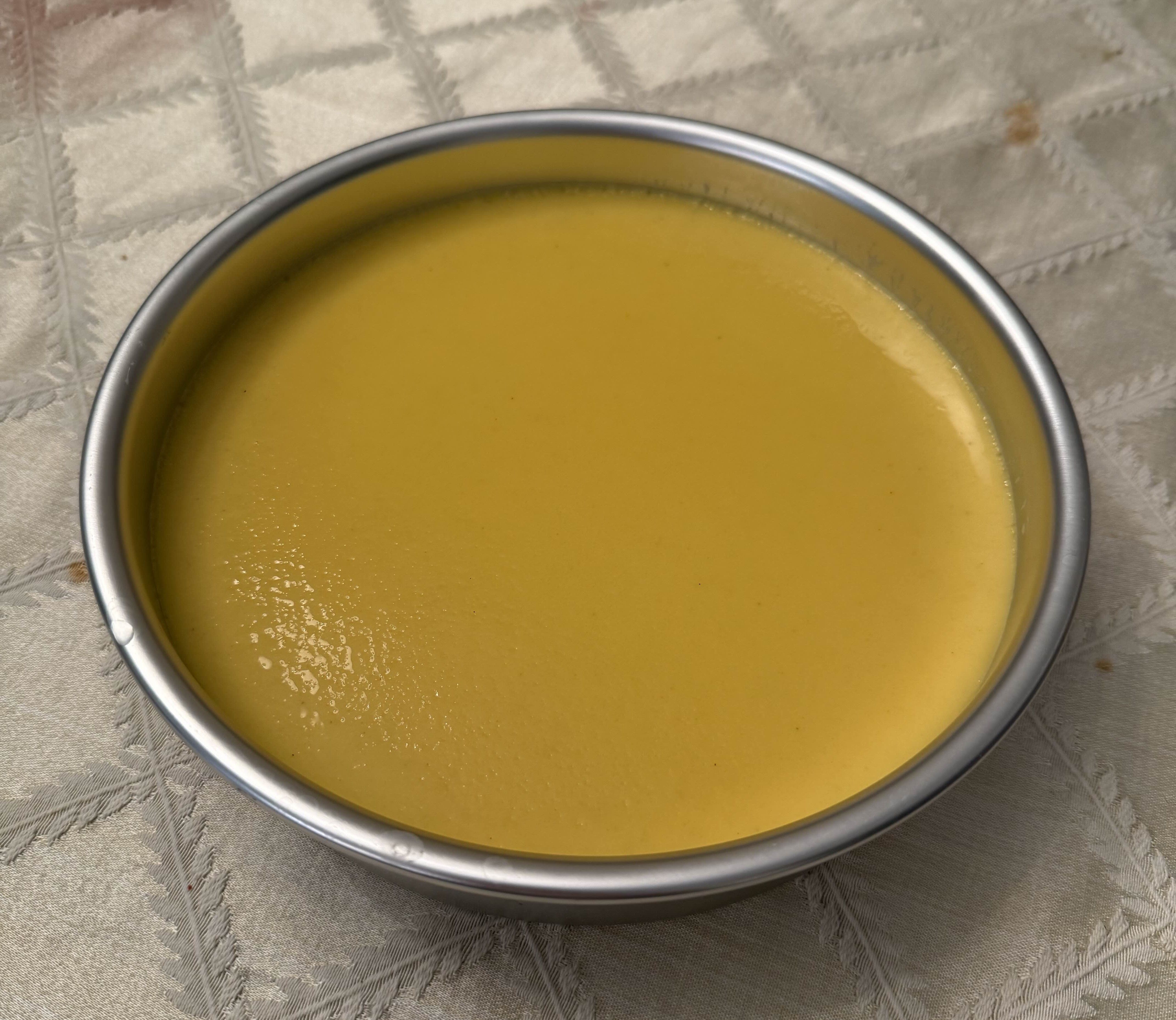 Custard in a round aluminum cake pan
